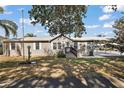 Inviting home featuring an attached carport, tidy lawn, and a mature shade tree at 37945 Monticello St, Leesburg, FL 34788