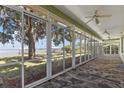 Screened-in patio offering panoramic lake views with ceiling fans and tiled flooring for outdoor relaxation at 38420 Langlois Pl, Leesburg, FL 34788