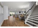 Spacious living room featuring wood floors, a dining area, and an open floor plan flowing into the kitchen at 4515 Lions Gate Ave, Clermont, FL 34711