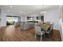 Bright open-concept living area featuring wood floors, comfortable seating, and a seamless flow to the kitchen at 4515 Lions Gate Ave, Clermont, FL 34711