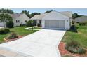 Exterior shot of a single story home featuring a large concrete driveway and manicured landscaping at 508 Carrera Dr, The Villages, FL 32159