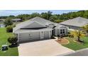Beautiful home with a well-kept lawn, three-car garage, and decorative landscaping, offering curb appeal at 5220 Horsford Path, The Villages, FL 32163