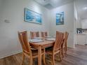 Cozy dining room features a wood table, six chairs, and beach-themed artwork with a view of the kitchen at 633 Jameston Ave, The Villages, FL 32162