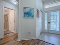 Inviting entryway featuring wood flooring, stylish decor, and plenty of natural light streaming through the glass doors at 633 Jameston Ave, The Villages, FL 32162