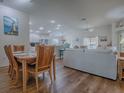 Open-concept living space with wood floors, dining area, living room, and bright kitchen with stainless steel appliances at 633 Jameston Ave, The Villages, FL 32162