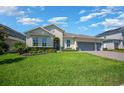 Inviting single-story home featuring a lush green lawn, mature landscaping, and a desirable three-car garage at 677 Brooks Field Dr, Winter Garden, FL 34787