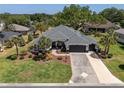 Overhead shot of a beautiful single-story home with a pristine lawn and driveway at 8715 Se 176Th Lowndes Pl, The Villages, FL 32162
