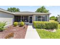 Inviting front porch with manicured bushes and flower beds leading to a welcoming entrance at 929 Eastmont Ct, The Villages, FL 32162