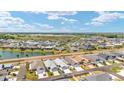 Expansive community aerial view showcasing the beautiful homes, pond, landscaping, and surrounding green spaces at 947 Couture St, The Villages, FL 32163