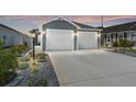 Charming home featuring a two-car garage, landscaped yard with rock detail and tasteful exterior lighting at 947 Couture St, The Villages, FL 32163