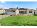 Charming single-story home features a well-manicured lawn, screened porch, two-car garage and solar panels at 9621 Se 168Th Maplesong Ln, The Villages, FL 32162
