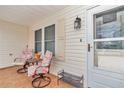 Cozy front porch with seating area, featuring tiled flooring and a decorative entrance door at 9621 Se 168Th Maplesong Ln, The Villages, FL 32162