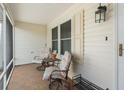 Relaxing screened porch area with tile flooring, two chairs, side table and outdoor lighting at 9621 Se 168Th Maplesong Ln, The Villages, FL 32162