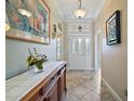 Inviting foyer with a decorative table, neutral walls, and diamond-patterned tile flooring at 1606 Mount Croghan Trl, The Villages, FL 32162