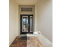 Close-up of decorative front door featuring glass design and brick tiled entry at 10282 Julia Isles Ave, Oxford, FL 34484