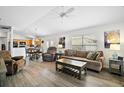 Open-concept living area with a comfortable sofa, wood-look floors, and views into the kitchen and dining area at 1084 Becker Ave, The Villages, FL 32163