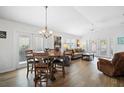 Bright and airy living room featuring hardwood floors, a vaulted ceiling, and a dining table with seating for four at 1084 Becker Ave, The Villages, FL 32163