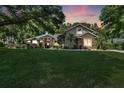 Charming single-story home with a large front lawn and stone facade accents at sunset at 10851 Lantana Crst, Clermont, FL 34711