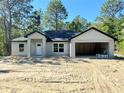 Unfinished single Gathering house has an attached garage with a white front door at 12 Guava Terrace Radl, Ocklawaha, FL 32179