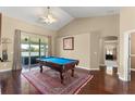 Spacious game room featuring a pool table, wood floors, ceiling fan, and access to an outdoor patio at 13045 Colonnade Cir, Clermont, FL 34711