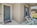 Inviting front porch featuring white Adirondack chairs, a blue door, and stylish exterior accents at 13328 Lake Yale View Loop, Grand Island, FL 32735