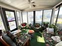 Bright sunroom with floral furniture, offering a relaxing space with natural light and outdoor views at 1616 Lauren Ln, Lady Lake, FL 32159