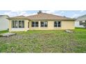 Exterior view of backyard with bright stucco, multiple windows, and enclosed sunroom at 17238 Se 94Th Coults Cir, The Villages, FL 32162