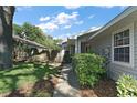 Landscaped front yard with a walkway leading to a gray one-story home on a sunny day at 20 Ginger Cir, Leesburg, FL 34748