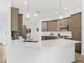 Bright kitchen with a large island, white countertops, gray cabinets, and stainless steel appliances at 2006 Oppenheimer Ct, The Villages, FL 34762