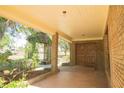 Inviting front porch with brick accents, wooden beams, and lush greenery leading to the detailed double door entry at 2112 Robie Ave, Mount Dora, FL 32757