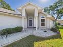 Inviting home exterior highlighting the well-maintained lawn, stone details, and covered front entrance at 21707 Queen Mary Ct, Leesburg, FL 34748