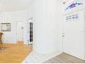 Bright foyer featuring tile and wood flooring, complemented by a decorative stained-glass window above the front door at 21707 Queen Mary Ct, Leesburg, FL 34748