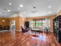 Spacious living room featuring hardwood floors, vaulted ceilings, and large windows at 21815 Tartan St, Leesburg, FL 34748