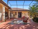 Outdoor patio with red pavers, seating, and a covered structure for shade at 21815 Tartan St, Leesburg, FL 34748