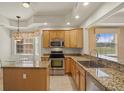 Well-equipped kitchen featuring granite countertops, stainless steel appliances, and wood cabinetry at 26207 Avenida Las Colinas # 26207, Howey In The Hills, FL 34737