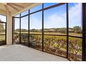 Relaxing screened lanai with a ceiling fan offers panoramic views of the lush green golf course at 26207 Avenida Las Colinas # 26207, Howey In The Hills, FL 34737