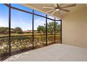 The screened lanai features a ceiling fan and views of the beautiful outdoor landscape at 26207 Avenida Las Colinas # 26207, Howey In The Hills, FL 34737