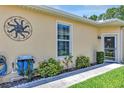 Charming home exterior featuring a well-manicured lawn, decorative sun ornament, and a tidy sidewalk at 26951 White Plains Way, Leesburg, FL 34748