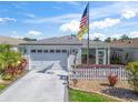 Inviting single-story home with manicured lawn and a white picket fence providing a warm curb appeal at 2729 Craven Way, The Villages, FL 32162