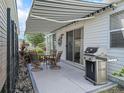The outdoor patio features a retractable awning, a dining set, and a modern stainless steel grill at 2729 Craven Way, The Villages, FL 32162