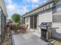 Outdoor patio featuring a retractable awning, dining table with seating, and a stainless steel grill at 2729 Craven Way, The Villages, FL 32162