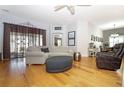Bright living room featuring hardwood floors, neutral-toned furniture, and sliding glass doors at 287 Ellenton Run, The Villages, FL 32162
