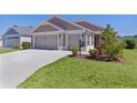 Beautiful home with a three-car garage and nicely landscaped front yard at 2919 Gulley Ln, The Villages, FL 32163