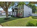 Landscaped corner lot with a two-story home featuring gray siding, white trim, and a well-manicured lawn at 30236 Pga Dr, Sorrento, FL 32776