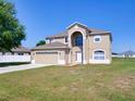 Inviting two-story home showcasing a well-manicured lawn and a two-car garage at 307 Big Black Ln, Poinciana, FL 34759