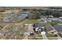 An aerial view of a home near a pond, showcasing the community and surrounding landscape at 308 Anorak St, Groveland, FL 34736
