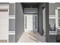 Close-up of the front entrance with a white door, sidelights, and transom window at 308 Anorak St, Groveland, FL 34736