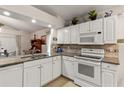 Kitchen boasting granite countertops, tiled backsplash, and white appliances with white cabinetry at 3785 Avon Ct, Clermont, FL 34711