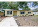 Charming yellow home with green shutters, manicured landscaping and a tidy front lawn at 3972 Poinsettia Ave, Mount Dora, FL 32757