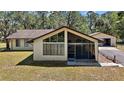 Lovely exterior of home with a screened porch and two-car detached garage at 40325 Emeralda Island Rd, Leesburg, FL 34788
